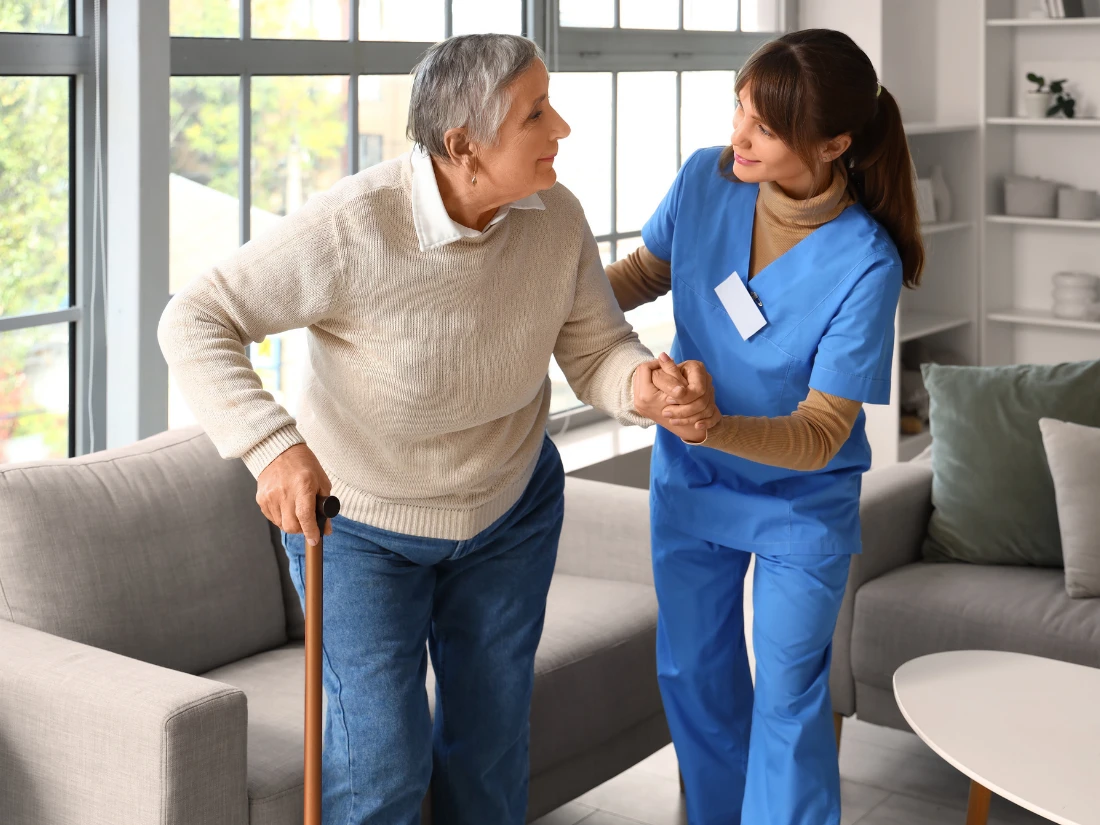 A certified home health aide assisting a senior with safe mobility and daily living activities at home in Alexandria City, VA.