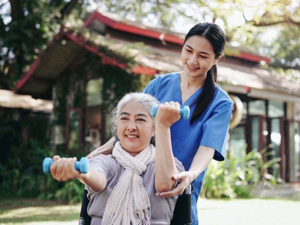A therapy professional supporting a senior during an outdoor rehabilitation session in Alexandria City, VA.